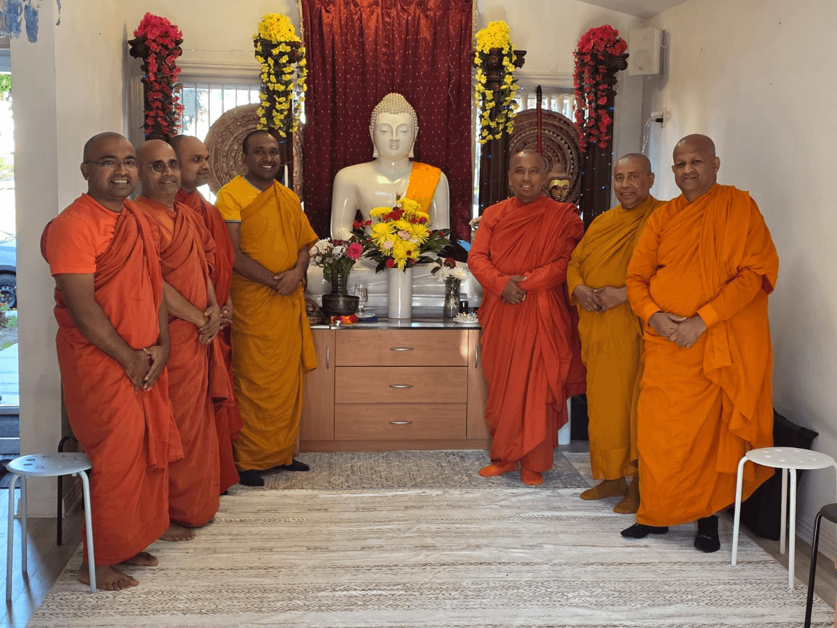 Resident monks of the Buddhist Centre of Montreal gathered in front of the Buddha statue